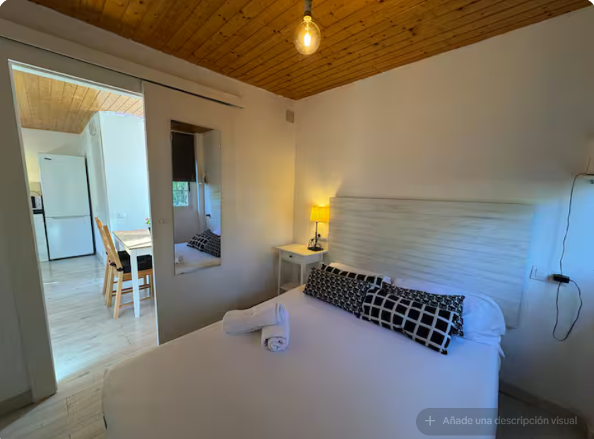 Dormitorio con cama de matrimonio y techo de madera